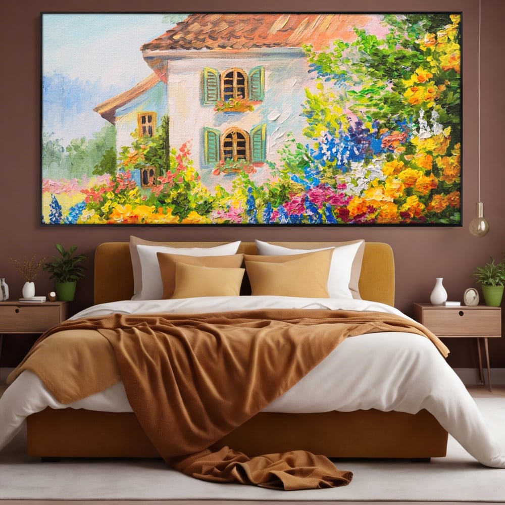 Tablou canvas cu pictura cu casa alba si flori, in rama de aluminiu negru, pe perete intr-un dormitor